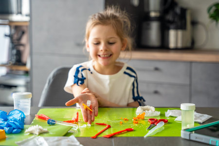 Child hand holding colorful crystals of different shapes at home science table. Crystal growing...