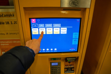 Prague, Czech republic - January 16, 2026: Passenger selecting ticket option on PID vending machine screen in Prague metro station. Public transport ticket purchase in Czech Republicのeditorial素材