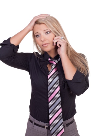 Worried beautiful blonde woman running her hand through her hair listening to a conversation on her mobile phone, studio portrait isolated on whiteの写真素材