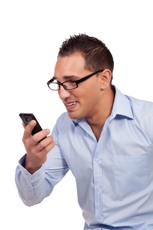 Man wearing heavy rimmed glasses holding up his mobile phone near his face and smiling as he reads a text message isolated on whiteの写真素材