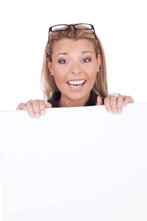 Studio shot of an attractive joyful woman behind blank white boardの写真素材
