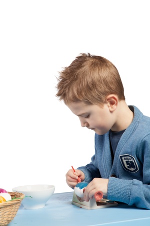 Cute little boy busy painting Easter eggsの写真素材