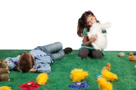 Easter theme with young boy lying down and girl cuddling her toy bunny の写真素材