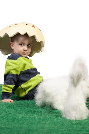 Easter them with young boy sitting on floor with egg shaped hat on his head looking at the camera の写真素材