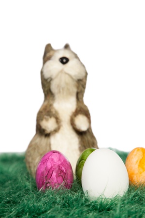 Easter decoration with a standing Easter bunny on green grass and painted eggsの写真素材