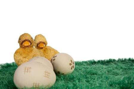 Painted easter eggs on green grass and yellow ducksの写真素材