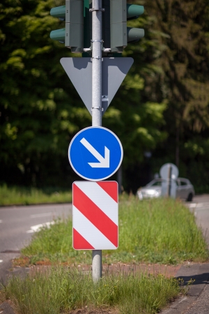 Red and white warning chevron with a right pointing arrow warning motorists of a central island in the road and to keep to the right hand sideの写真素材