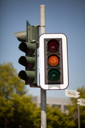 Amber traffic light warning of a progression to a red light bringing trafic to a halt at an intersectionの写真素材