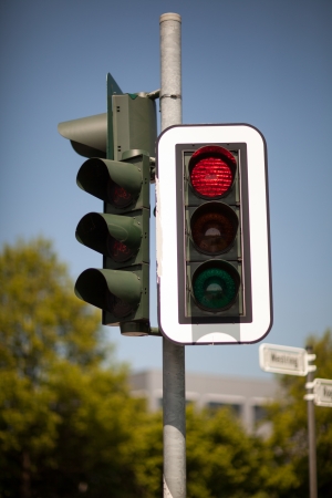 Set of urban robots mounted on a pole with the red traffic light illuminated bringing cars to a haltの写真素材