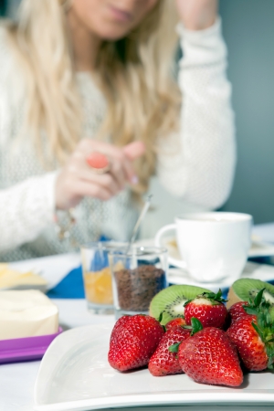 Closeup view of a plate of delicious whole ripe strawberries with halved kiwi fruit served for breakfastの写真素材