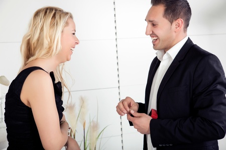 Overjoyed couple smiling at each other with love as she accepts his offer of marriage and the engagement ringの写真素材