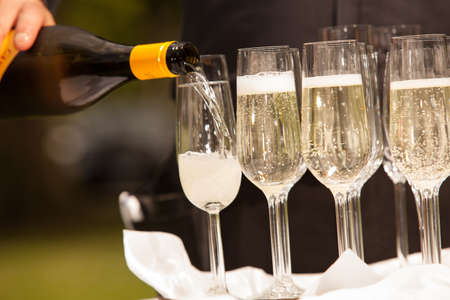 The waitress is filling some glasses of sparkling wine の写真素材