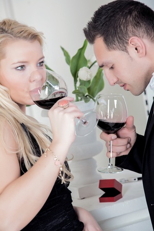 A young couple is tasting a glass of wine の写真素材