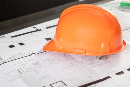 A orange helm is laying on a architecture floor plan.の写真素材