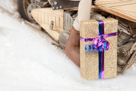 A golden Christmas Present in front of a motorcycle with a lot of copyspace の写真素材