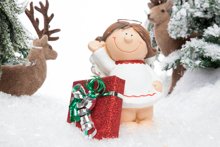 A smiling cartoon child guarded by two reindeers presents a X-Mas Gift の写真素材