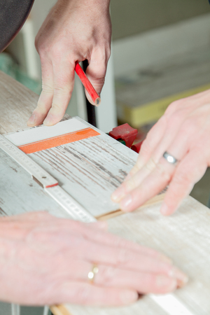 A man is measuring the correct length of the laminate panel の写真素材