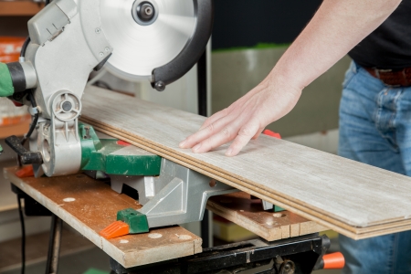 A man is sawing a piece of laminate with a buzz saw の写真素材