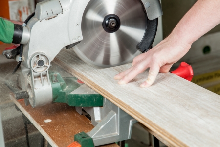 A buzz saw is sawing a piece of laminate の写真素材