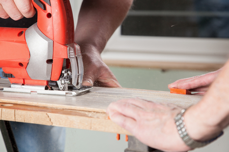 Two Peoples are sawing a piece of Laminate の写真素材