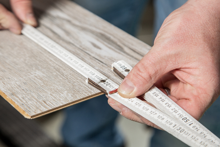 A Carpenter is measuring the right length of the laminate の写真素材