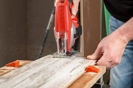 A carpenter is sawing along a straight pencil line の写真素材
