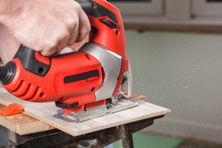 A man is marking with a jig saw in his garage の写真素材
