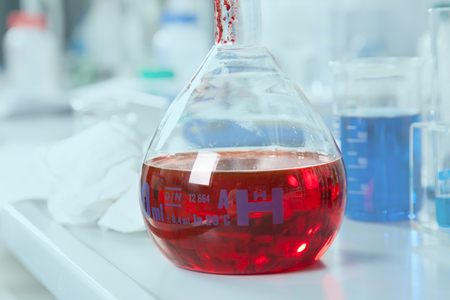 A chemical round bottom flask with a red Liquid の写真素材