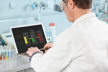 The Chemist is examining the Test Result on his PC の写真素材