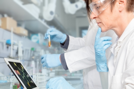 A Doctor is doing some drug research on an electronic device の写真素材