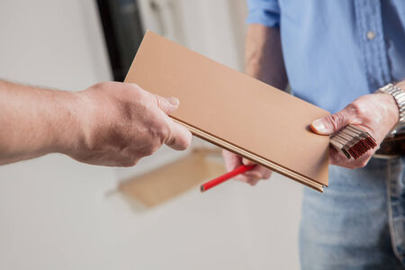 Two People are exchanging a piece of laminate の写真素材