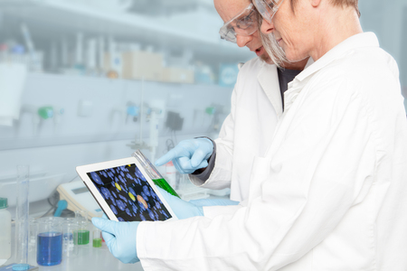 A Team of Chemist are analysing the result of an Experiment on a mobile device の写真素材