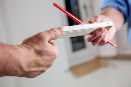Two workers are exchanging a Yardstick の写真素材