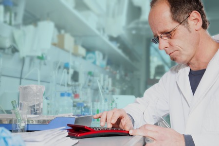A Chemist typing on his calculator to calculate the right mixture ratio 