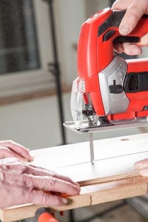 The Carpenter is pushing the laminate towards the jigsaw.の写真素材