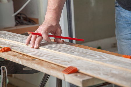 A man chucked a piece of wood into the bench vice before sawing の写真素材