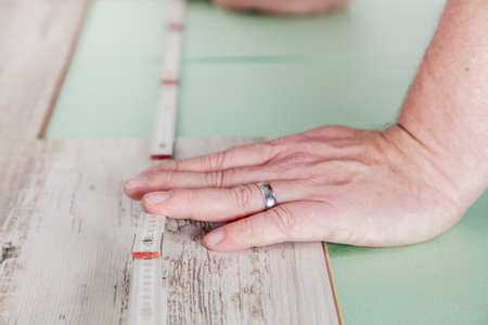 A worker measures the perfect length for the laminate の写真素材