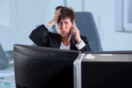 A Business woman is stressed out during a phone call の写真素材