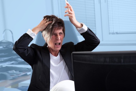 An angry Secretary is crying and shouting in her Office の写真素材