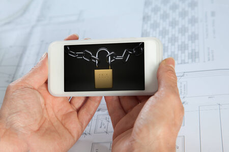 A Smartphone shows a padlock from the National Security Agency with two chainsの写真素材