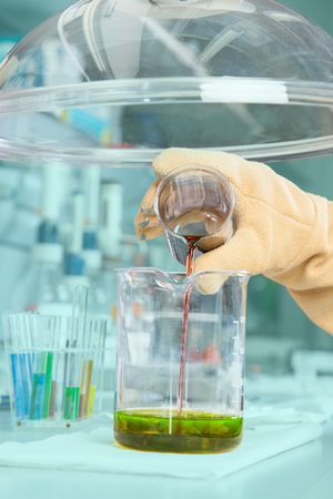 The Chemist is mixing a greenish substance の写真素材