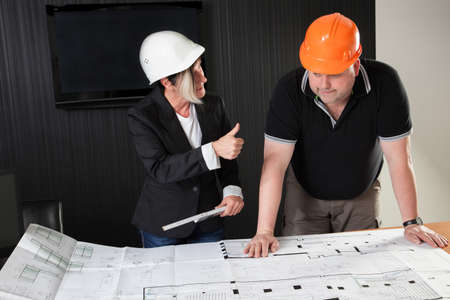 An Architect giving the thumbs up sign to her workerの写真素材