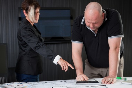 An Architect is pointing to a mobile deviceの写真素材