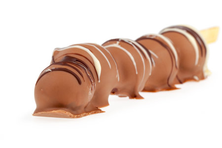 Some chocolate balls stringed like a snake isolated on a white background の写真素材