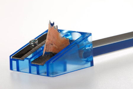 A blue pencil sharpener with a pen on a white background の写真素材