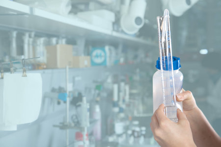 A woman is decanting some distillated water into a test tube の写真素材