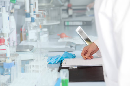 A chemist is thinking what to write down in her laboratory の写真素材