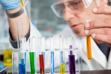 A Chemist is using a pipette to refill a test tube の写真素材