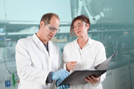 Two chemists are doing some paper work in there laboratory の写真素材