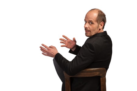 A well dressed Businessman is sitting on a chair to explain something on a white background の写真素材